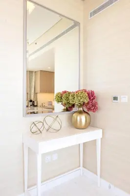 a mirror on a white table with flowers on it at Ultra Luxury Palm Tower with Shared Hotel Facilities in Dubai