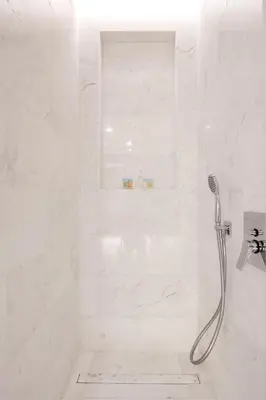 a white shower with a shower head in a bathroom at Ultra Luxury Palm Tower with Shared Hotel Facilities in Dubai