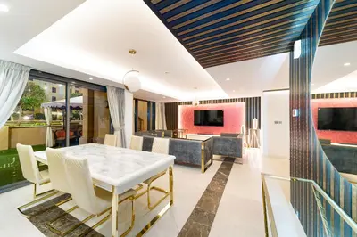 a dining room with a table and a living room at ELAN RIMAL SADAF Suites in Dubai