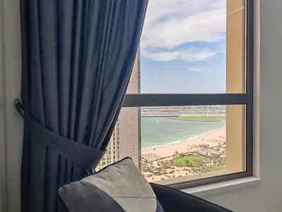 a room with a window with a view of the beach at ELAN RIMAL SADAF Suites in Dubai