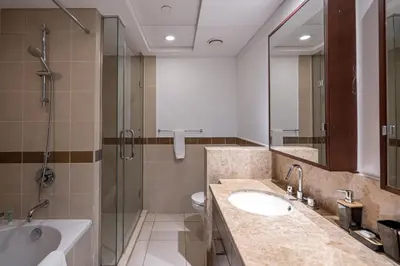 a bathroom with a sink and a shower and a toilet at Bellavista - Glamorous - 2BR - 29 Boulevard - Burj Khalifa & Fountain View in Dubai