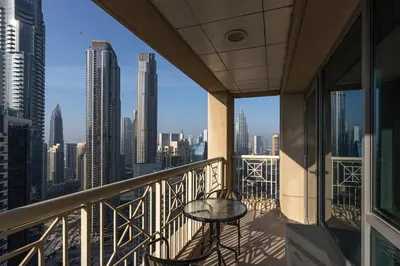 a balcony with a table and a view of a city at Bellavista - High Floor - 1BR - 29 Boulevard - Full Burj Khalifa & Fountain View in Dubai