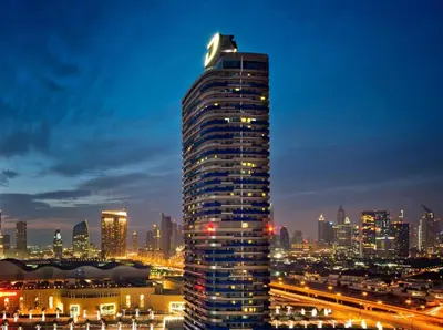 a tall building in a city at night at Damac Mall Street Residences in Dubai
