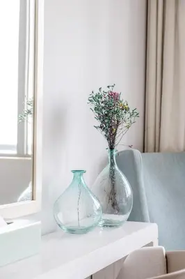 two vases sitting on a table with flowers in them at Damac Mall Street Residences in Dubai