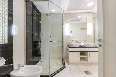 a bathroom with a glass shower and a sink at Damac Mall Street Residences in Dubai