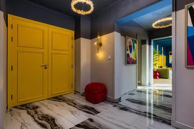 a hallway with a yellow door and a red stool at High-End Designer Penthouse Full Burj Khalifa View in Dubai