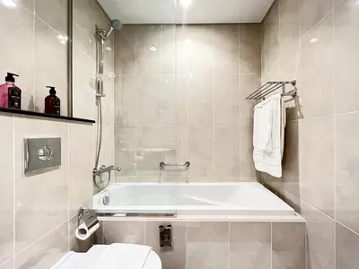 a bathroom with a bath tub and a toilet at Trophy Stays - Peaceful Golf side Escape Studio - Damac Hills in Dubai