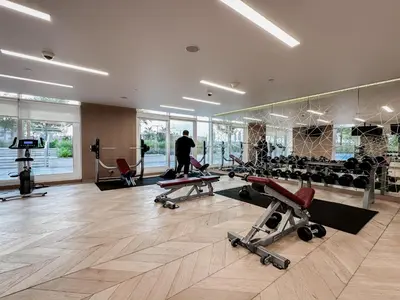 a man is walking in a gym with several exercise equipment at Trophy Stays - Peaceful Golf side Escape Studio - Damac Hills in Dubai