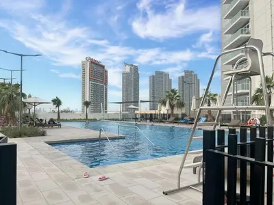 a swimming pool in a city with tall buildings at Trophy Stays - Peaceful Golf side Escape Studio - Damac Hills in Dubai