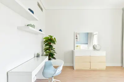 a white room with a desk and a blue chair at Luxury Beachfront Palm Jumeirah I Free 5 Star Beach Resorts Access in Dubai
