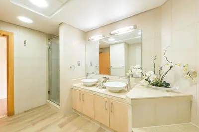 a bathroom with two sinks and a large mirror at Luxury Beachfront Palm Jumeirah I Free 5 Star Beach Resorts Access in Dubai