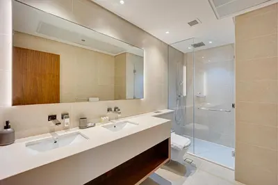 a bathroom with two sinks and a shower at Spacious 2 Bedroom in Marina Gate Jumeirah Living in Dubai