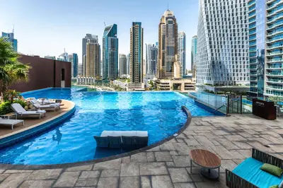 a swimming pool on the roof of a building with a city skyline at Spacious 2 Bedroom in Marina Gate Jumeirah Living in Dubai