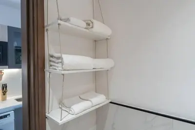 a white towel rack with towels on it in a bathroom at Tropical Loft with working station in JVC in Dubai