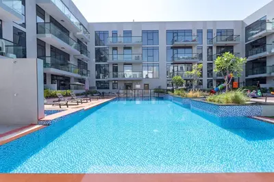 a swimming pool in the middle of a building at Tropical Loft with working station in JVC in Dubai