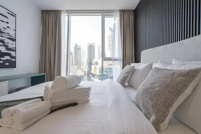 a bedroom with a white bed with towels on it at Cosmopolitan Apartment with Burj Khalifa View in Dubai