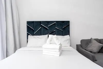 a bedroom with a white bed and a couch at Cozy studio in heart of Dubai - JVC in Dubai