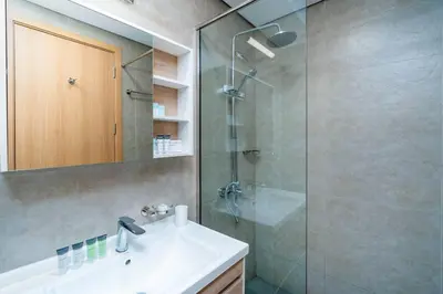 a bathroom with a sink and a glass shower at Cozy studio in heart of Dubai - JVC in Dubai
