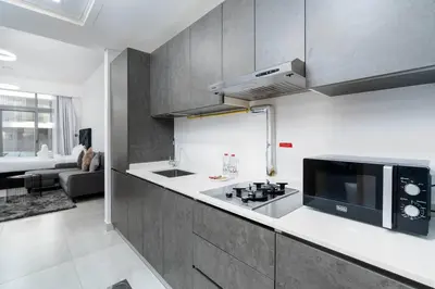 a kitchen with a microwave and a stove top oven at Cozy studio in heart of Dubai - JVC in Dubai