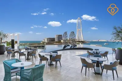 a restaurant with tables and chairs and a ferris wheel in the background at Keysplease Luxury 1 BR Apt Address W Private Beach, JBR in Dubai