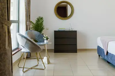 a bedroom with a chair and a bed and a mirror at 2BR in JBR / Sea View / Dubai Marina / Walk2Beach in Dubai