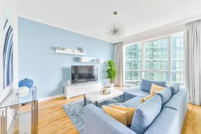 a living room with a blue couch and a tv at Al Bateen · Ultra Luxury JBR · Private Beach and Pool in Dubai