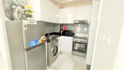a kitchen with a washing machine and a refrigerator at Amazing stay in Majan Dubai in Dubai