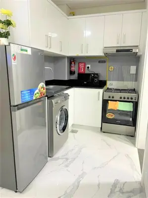 a kitchen with a washing machine and a stove at Amazing stay in Majan Dubai in Dubai