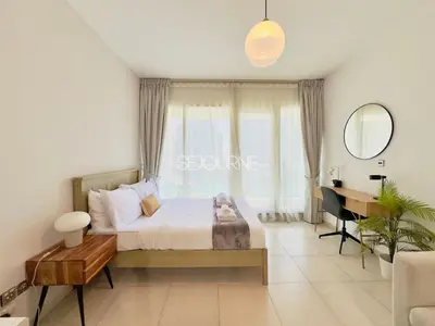 a bedroom with a bed with a desk and a window at DA86 - Well Design Studio in Dubai Arch tower in Dubai