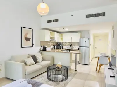 a living room with a couch and a kitchen at DA86 - Well Design Studio in Dubai Arch tower in Dubai