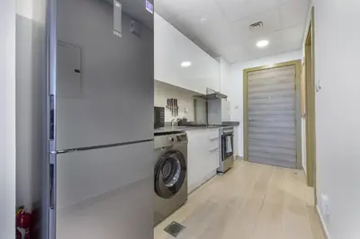 a kitchen with a refrigerator and a washer and dryer at Spectacular Views of Dubai Skyline in Dubai