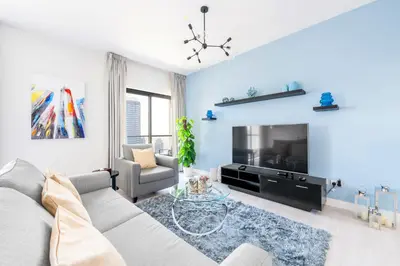 a living room with a couch and a tv at Luxury JBR Shams - Marina View - Free 5 star Beach Resorts Access! in Dubai