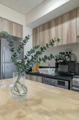 a kitchen with a table with a vase with a plant at City View I 1 Bedroom Apartment I Golf Vita, Damac Hills in Dubai