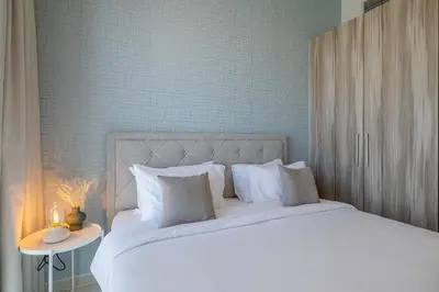 a bed with white sheets and pillows in a bedroom at City View I 1 Bedroom Apartment I Golf Vita, Damac Hills in Dubai