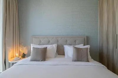 a bed with white sheets and pillows in a bedroom at City View I 1 Bedroom Apartment I Golf Vita, Damac Hills in Dubai