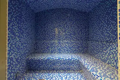 a blue tiled room with a bench in the corner at Gala Guests - Marasi Drive City View Apartments in Dubai