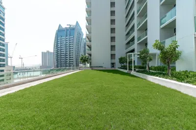 a green lawn on the roof of a building at Gala Guests - Marasi Drive City View Apartments in Dubai