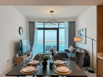 a living room with a dining room table with a view at Beachfront 2BR with Spectacular Sea and Palm Views - 17AB06 in Dubai