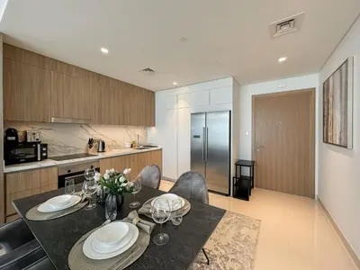 a kitchen and dining room with a table and chairs at Beachfront 2BR with Spectacular Sea and Palm Views - 17AB06 in Dubai