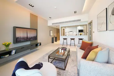 a living room with a couch and a tv at Cheval Maison - The Palm in Dubai