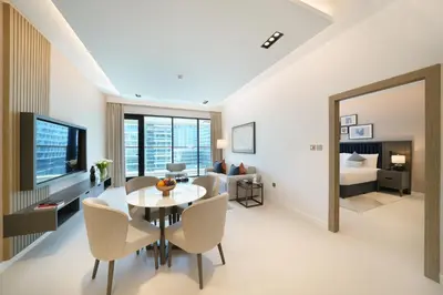 a living room with a table and chairs and a bedroom at Cheval Maison - The Palm in Dubai
