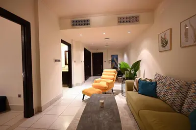 a living room with a couch and some chairs at Old Town- Heart of Downtown. in Dubai