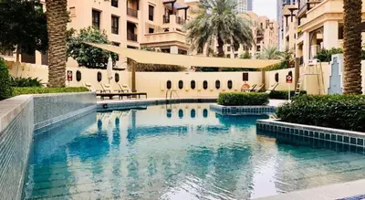 a swimming pool with blue water in a city at Old Town- Heart of Downtown. in Dubai