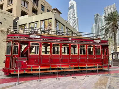 a red trolley car parked in front of a building at Old Town- Heart of Downtown. in Dubai