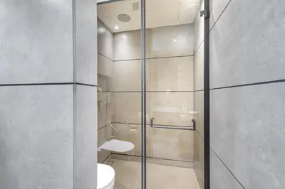 a bathroom with a toilet and a glass shower at Beautiful, Stylish and Peaceful 1BD in JVC in Dubai