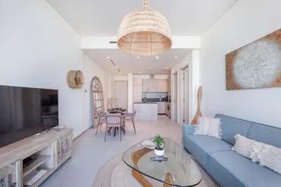 a living room with a blue couch and a table at Beautiful, Stylish and Peaceful 1BD in JVC in Dubai