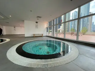 a large swimming pool in a building with windows at DA84 - Chic Studio in Dubai Arch Tower in Dubai