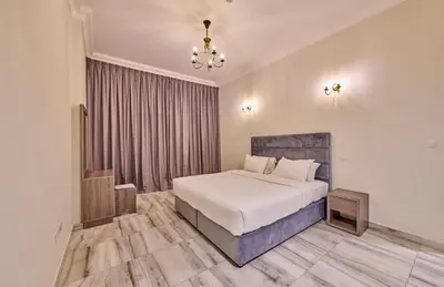 a bedroom with a white bed and a chandelier at Grand Stay Holiday Homes Al Jaddaf in Dubai
