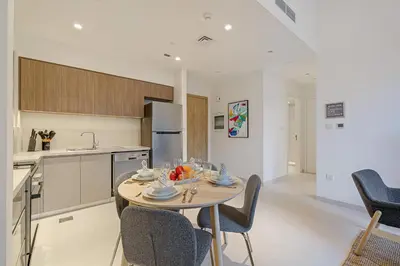 a kitchen and dining room with a table and chairs at Brand New 1BR in Dubai Hills Quiet and Peaceful in Dubai