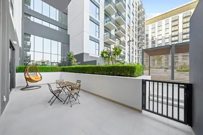 a balcony with a table and chairs on a building at Brand New 1BR in Dubai Hills Quiet and Peaceful in Dubai